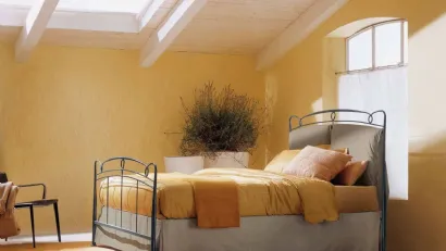 Letto in ferro battuto con testiera in tessuto imbottito e contenitore Versilia di Bontempi